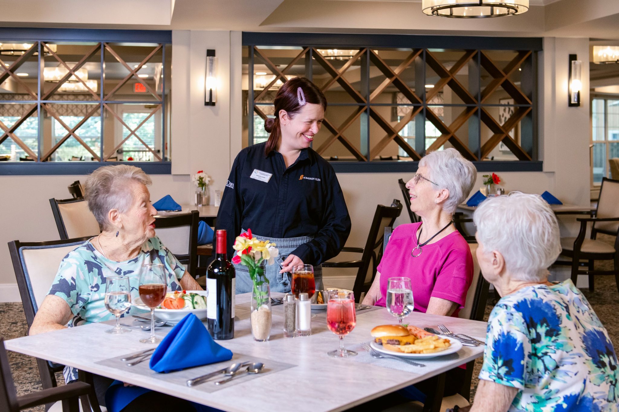 Someren Glen Senior Living Community in Centennial, CO - three residents and dining team member talking largelandscape